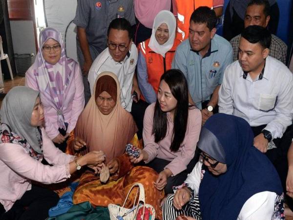 Cai Tung (dua dari kanan) beramah mesra dengan mangsa banjir di PPS Sekolah Kebangsaan Gembut, Kota Kota Tinggi hari ini. - Foto Bernama