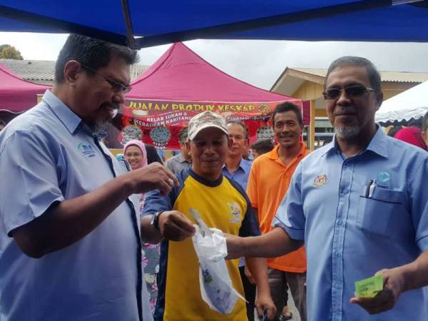 Tengku Mohd Anuar (kanan) dan Zawawi (kiri) melelong ikan sempena 'happy hour' pada Hari Bertemu Pelanggan Peringkat MOA INC Terengganu anjuran LKIM dan Jabatan Perikanan Terengganu di pekarangan pejabat LKIM negeri, pelabuhan LKIM Chendering di sini hari ini.