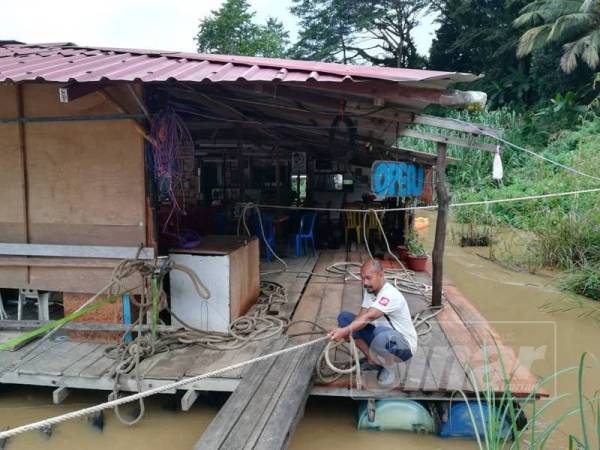 Mohd Shukri membuat persediaan di restoran terapung miliknya.