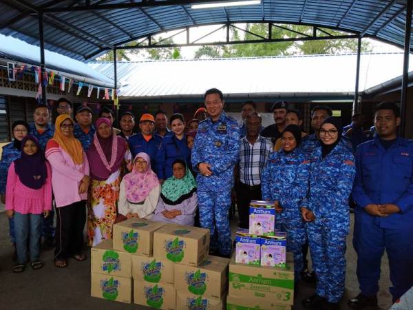 Tengku Kamarulzaman (lima dari kanan) menyampaikan bantuan di PPS Balairaya Kampung Contoh Kahang Kluang semalam.