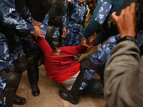 Polis mengheret seorang penunjuk perasaan yang menyertai protes di New Delhi hari ini. - Foto: AFP