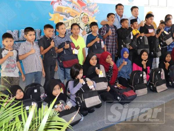 Sazally bergambar bersama penerima sumbangan Kembali Ke Sekolah di Kompleks Operasi Litrak di sini hari ini.