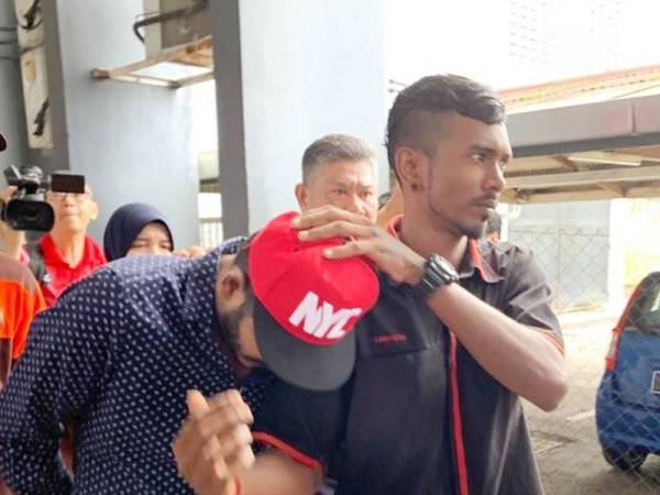 Chandru (kiri) ketika dihadapkan ke Mahkamah Sesyen Ipoh hari ini.