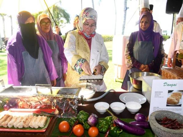 Raja Permaisuri Agong, Tunku Hajah Azizah Aminah Maimunah Iskandariah berkenan memasak kuih dangai pada Majlis Santapan Tengah Hari bersama Kepimpinan Wanita Pulau Pinang dan Majlis Ramah Mesra bersama Persatuan Chef Pulau Pinang di sini hari ini. - Foto Bernama