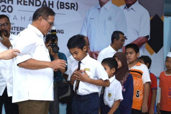 Wan Rosdy menyampaikan sumbangan kepada murid pada Majlis Penyampaian Biasiswa Sekolah Rendah (BSR) Yayasan Pahang 2020 Kawasan Jelai di Dewan UMNO Cameron Highland, Sungai Koyan, semalam.