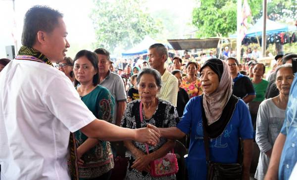 Peter Anthony (kiri) bersalaman dengan orang ramai yang menghadiri Majlis Santai Krismas di Dewan Pisompuruan Kampung Ulu Tepoh Tenom hari ini. - Foto: Bernama