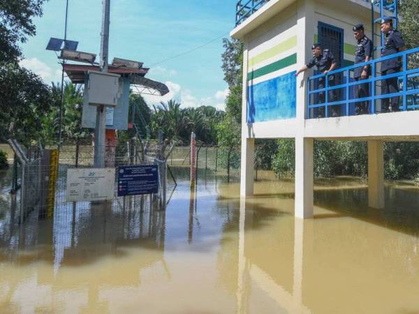 Ab Rashid (kiri) bersama pegawai meninjau paras air Sungai Golok ketika melawat kawasan di Balai Polis Kuala Jambu hari ini. - Foto Bernama