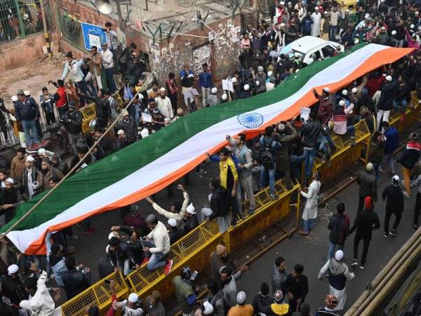 Kumpulan penunjuk perasaan membawa bendera kebangsaan di hadapan Masjid Jama ketika demonstrasi membantah undang-undang kerakyatan di New Delhi.