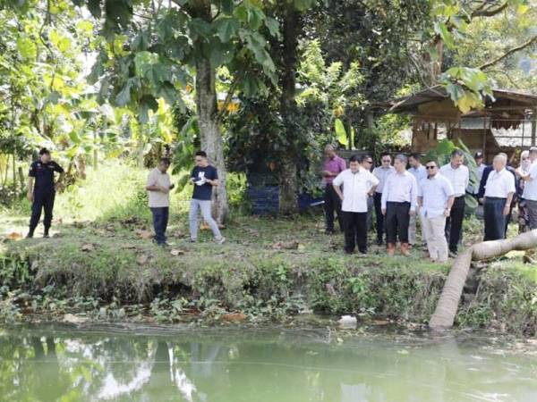 Amirudin (kanan) meninjau kerja pengepaman di Tasik Idaman Dengkil ke Sungai Semenyih bagi mencairkan pencemaran bau.