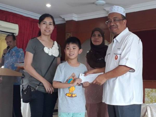 Phahrolrazi (kanan) menyampaikan baucar bernilai RM100 kepada pelajar sempena program Jom Ke Sekolah anjuran Nafas di SMK Convent, Alor Setar semalam.