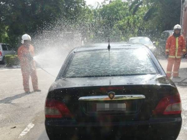 Anggota bomba memadamkan kebakaran melibatkan kereta Proton Waja yang terbakar di ruang parkir hadapan Pejabat JPJ Sabak Bernam semalam.