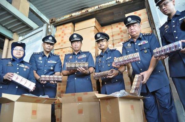 Mohammad Hamiddan (tiga dari kiri) menunjukkan sebahagian rokok putih yang dirampas dalam serbuan berkenaan.