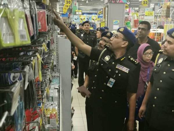 Azman menjalankan pemeriksaan harga barangan sekolah di sebuah hypermarket di Bandar Teknologi Kajang di sini, hari ini.