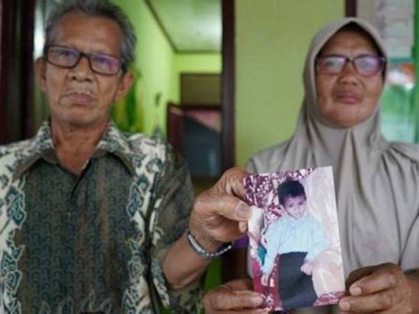 Saudah bersama suami menunjukkan satu-satunya gambar Muhammad Siddiq yang masih ada dalam simpanannya. - Foto BBC Indonesia