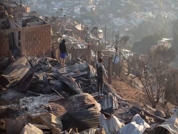 Penduduk tempatan melihat kemusnahan akibat kebakaran hutan di Bukit Rocuant di Valparaiso, Chile kelmarin. - Foto AFP