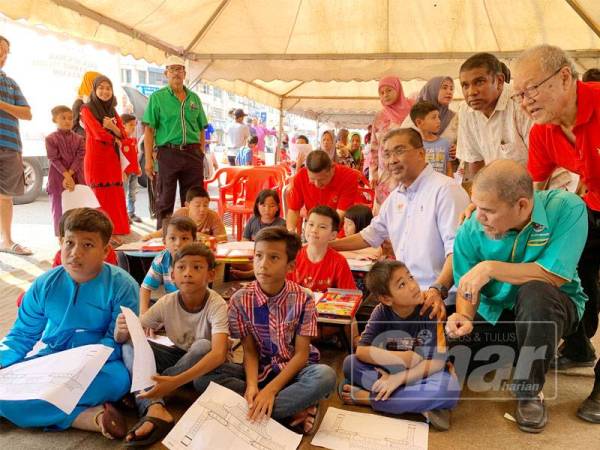 Takiyuddin (duduk, dua dari kanan) bersama peserta yang menyertai pertandingan mewarna sempena program Back To School, Gunting Rambut Percuma Antara Kaum anjuran Lajnah Perpaduan Nasional Pas Kawasan Kota Bharu hari ini.