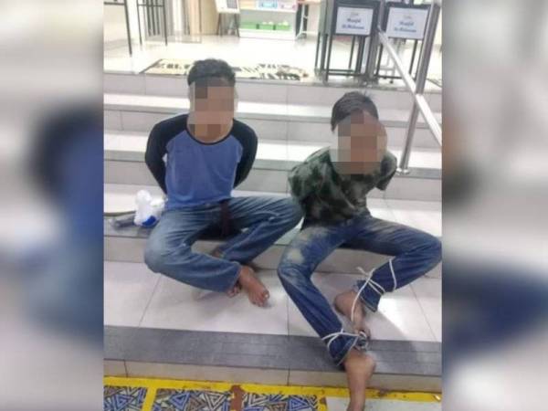 Dua lelaki ditahan penduduk selepas disyaki memancing wang tabung masjid di Parit Buntar semalam. - Foto ihsan pembaca