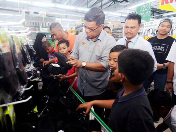 Saifuddin Nasution beramah mesra dengan sebahagian 150 murid kurang berkemampuan dari Parlimen Kulim yang menerima sumbangan peralatan sekolah pada Program Kembali Ke Sekolah di Econsave Alma hari ini. - Foto Bernama