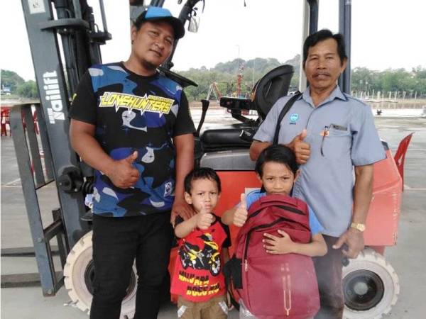 Tumiran (kiri) bergambar bersama Muhammad Aiman (dua dari kanan) sempena Program Kembali Ke Sekolah di Kompleks LKIM Kuala Selangor hari ini.