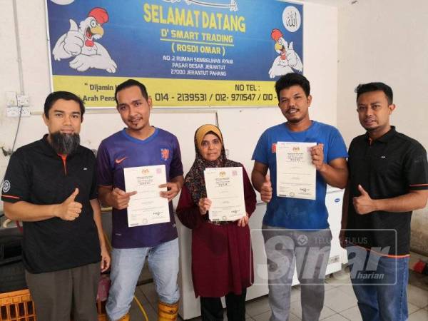 Noridzuan (kiri) bersama pengusaha premis penyembelihan ayam di Pasar Jerantut yang dianugerahkan Sijil Halal Malaysia kelmarin.