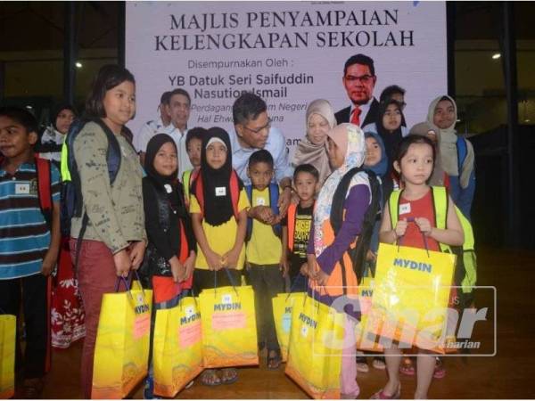 Saifuddin beramah mesra dengan murid sekolah yang menerima bantuan sekolah di Program Kembali Ke Sekolah bersama Mydin di Mydin Bukit Mertajam tadi.