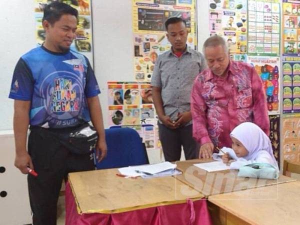 Mustafa Kamal (kanan) beramah mesra dengan Nur Zahirah Aisyah ketika hari pertama persekolahan di SK Sungai Jernih, Lubok China hari ini.