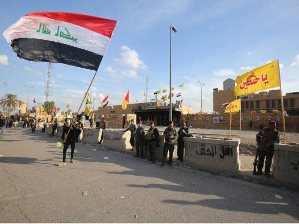 Anggota keselamatan Iraq ditempatkan di hadapan Kedutaan AS di Baghdad selepas kumpulan protes pro-Iran bersurai semalam. - Foto: AFP