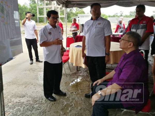 Saifuddin diberikan taklimat berhubung status Projek Perumahan Rakyat Chendor yang terbengkalai daripada wakil KPKT selepas turun padang meninjau tapak projek itu semalam.