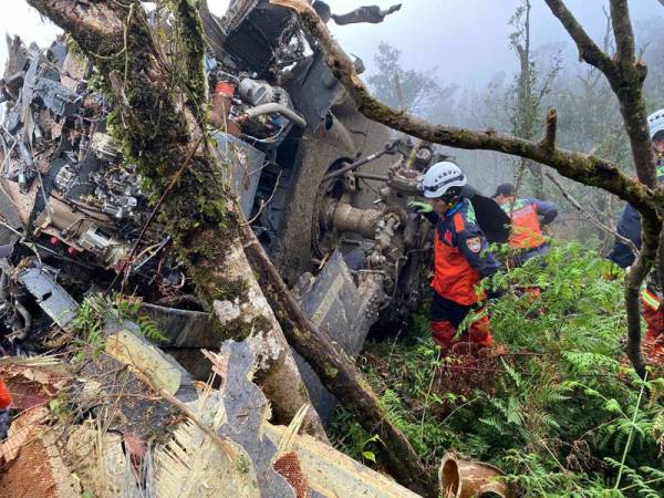 Anggota penyelamat mencari mangsa yang terselamat selepas helikopter UH-60M terhempas semalam. - Foto AFP