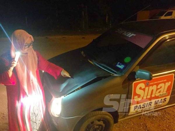 Hazelen Liana menunjukkan keadaan keretanya yang rosak selepas dirempuh lembu 'tidak bertuan' di jalan Rantau Panjang Lama.