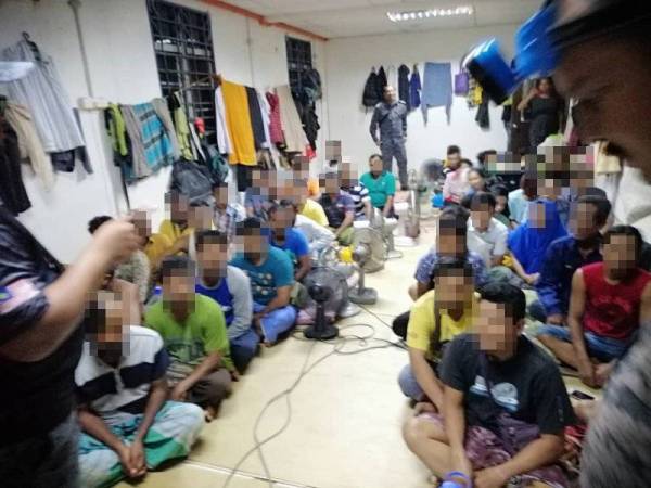 Sebahagian warga asing dikumpulkan di satu ruang untuk pemeriksaan lanjut dalam serbuan di sebuah bangunan kedai dua tingkat Jalan Pekan Kuala Berang, Hulu Terengganu pagi tadi. - Foto Ihsan JIM Terengganu