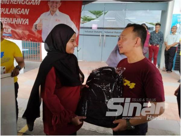 Dr Maszlee menyampaikan sumbangan beg sekolah kepada seorang penduduk pada Majlis Bersama Penduduk Simpang Renggam hari ini.