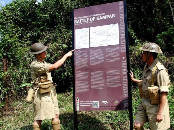 Shaharom (kiri) menunjukkan papan tanda yang baru dibina berkenaan maklumat tapak peninggalan sejarah Pertempuran di Kampar atau lebih dikenali sebagai 'Battle of Kampar' semasa Perang Dunia Kedua di Rabung Hijau, Gunung Bujang Melaka hari ini. -foto: Bernama