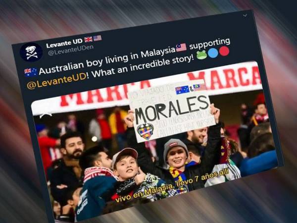 Remaja menunjukkan kadbod yang turut tertera Jalur Gemilang mencuri perhatian lensa jurufoto di stadium.