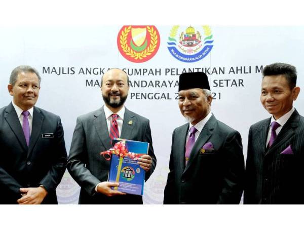 Mukhriz (dua dari kiri) menerima cenderahati daripada Mohd Zohdi (dua dari kanan) selepas majlis angkat sumpah pelantikan Ahli-Ahli Majlis Majlis Bandaraya Alor Setar (MBAS) penggal 2020-2021 hari ini.