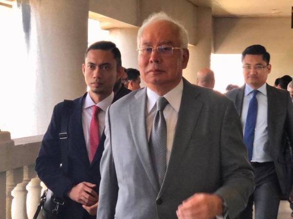 Najib kelihatan keluar dari bilik Mahkamah Tinggi Jenayah 3 selepas memberi keterangan bagi prosiding membela diri terhadap pertuduhan berhubung dana SRC International Sdn Bhd hari ini.