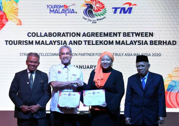 Dr Noor Zari Hamat (kiri) dan Pengerusi TM, Rosli Man (kanan) menyaksikan Pertukaran Dokumen Kerjasama antara TM dan Tourism Malaysia yang diwakili oleh Ketua Pengarah Tourism, Datuk Musa Yusof (dua dari kiri) dan Naib Presiden Group Brand and Communication TM Izlyn Ramli (dua dari kanan) pada Majlis Pertukaran Dokumen Kerjasama di Menara Kuala Lumpur hari ini. - Foto: Bernama
