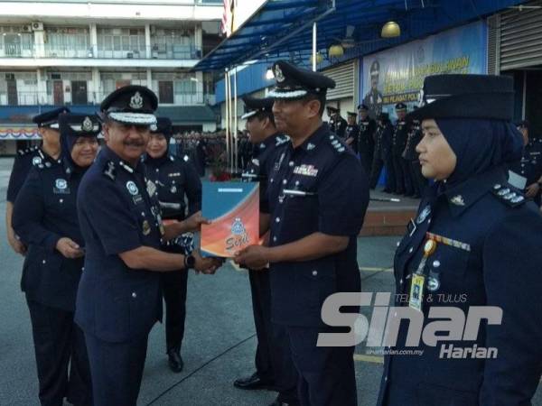 Razarudin (kiri) menyampaikan surat penghargaan kepada anggota polis yang memberikan sumbangan serta mengharumkan nama jabatan sempena Perhimpunan Bulanan Kontinjen Perak bagi Bulan Januari 2020 di pekarangan Ibu Pejabat Polis Kontinjen (IPK) Perak di sini hari ini.