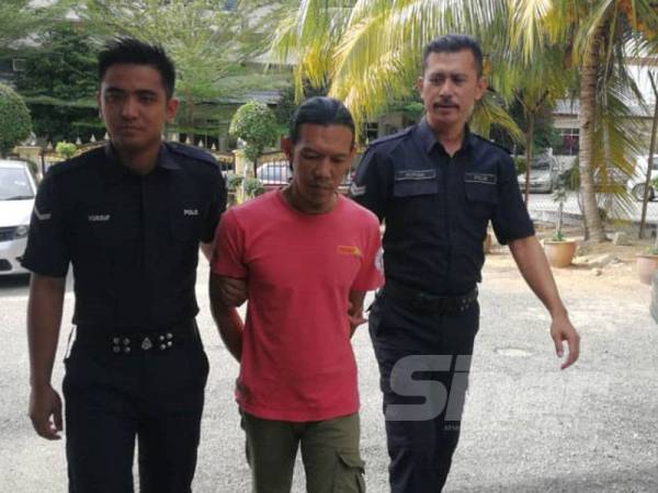 Tertuduh ketika dibawa anggota polis ke Mahkamah Majistret Tampin hari ini. 