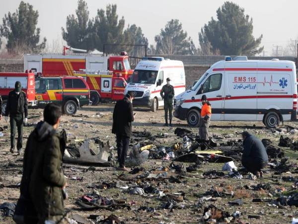 Pasukan penyelamat memeriksa serpihan nahas pesawat yang terhempas berhampiran Tehran semalam. - Foto AFP