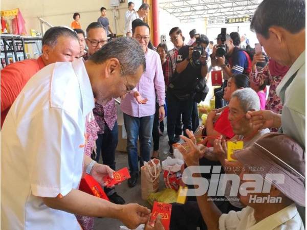 Dr Dzulkefly (kiri) menyampaikan sumbangan kepada penerima pada Majlis Sumbangan Fakir Miskin Sempena Perayaan Tahun Baru Cina di Tokong Tian Hock, Kuala Selangor di sini hari ini.