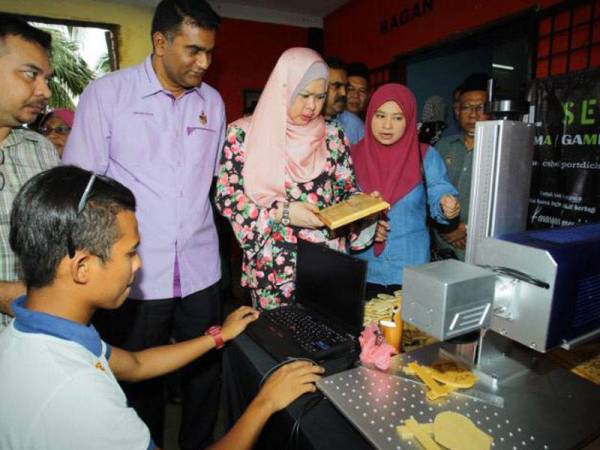 Rina (tengah) semasa melawat pameran, pada Program Ramah Mesra dan Ziarah Kasih Bersama Masyarakat DUN Bagan Pinang, hari ini.