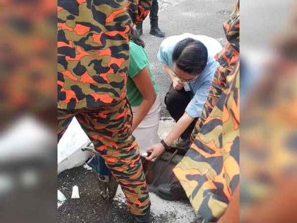 Pasukan bomba bersama pegawai perubatan berada di lokasi kejadian bagi mengeluarkan kaki kiri doktor wanita yang tersepit dalam jeriji longkang di HRPB Ipoh hari ini. - Foto Ihsan BOMBA PERAK