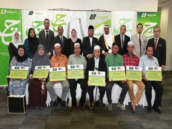 Dr Mujahid (lima dari kanan), Mahmoud Hussien (empat dari kanan) dan Fuziah (lima dari kiri) bergambar bersama mangsa dan waris kemalangan kren di Mekah pada Majlis Penyerahan Sumbangan yang diadakan di Jabatan Kemajuan Islam Malaysia hari ini. FOTO: ZAHID IZZANI