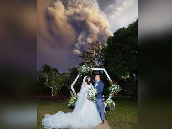 Kat Palomar dan Chino Vaflor meneruskan perkahwinan mereka walaupun asap dan abu meletus di gunung berapi Taal. - Foto Randolf Evan Photography