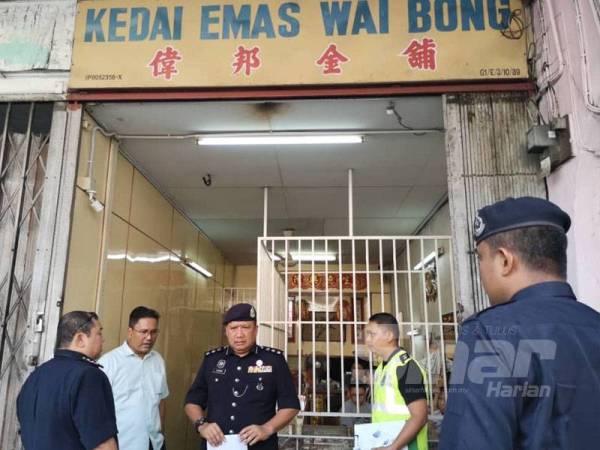 A Asmadi (tengah) ditemui di lokasi kejadian selepas menerima laporan kejadian samun kedai emas di Menglembu hari ini. 