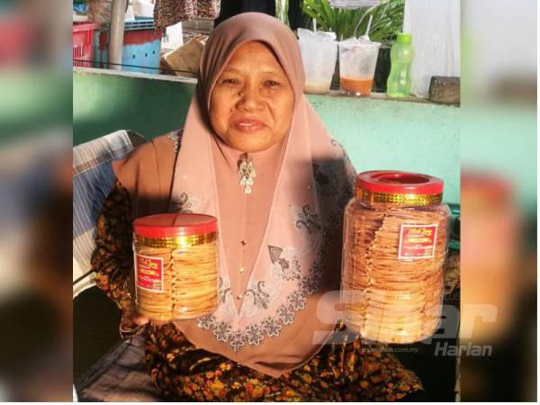 Kamsiah menunjukkan kuih kapit yang sedia dijual kepada pelanggannya.