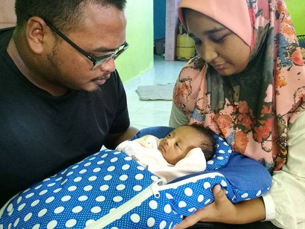 Nurul Suhada dan Abdul Rahim bersama bayi mereka, Abdul Raihan di kediaman di Kg Binjai Bongkok, Marang