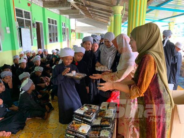 Pelajar tahfiz gembira menerima makanan yang disediakan olrj Hotel Royal Guest House untuk dinikmati secara beramai-ramai hari ini.