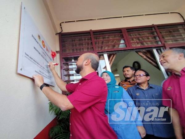 Mukhriz menandatangani plak perasmian Rumah Transit Negeri Kedah di sini hari ini.